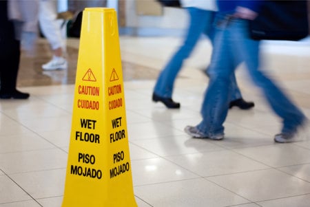 Floor with CAUTION: WET FLOOR sign to prevent slip and fall injuries